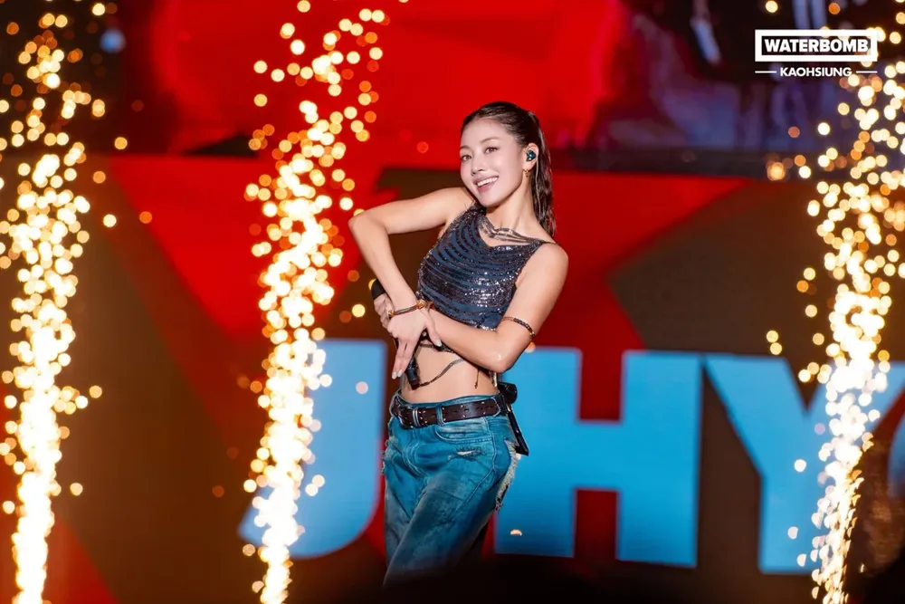 Jihyo performing on stage at Waterbomb Kaohsiung, with sparkler fountains behind her