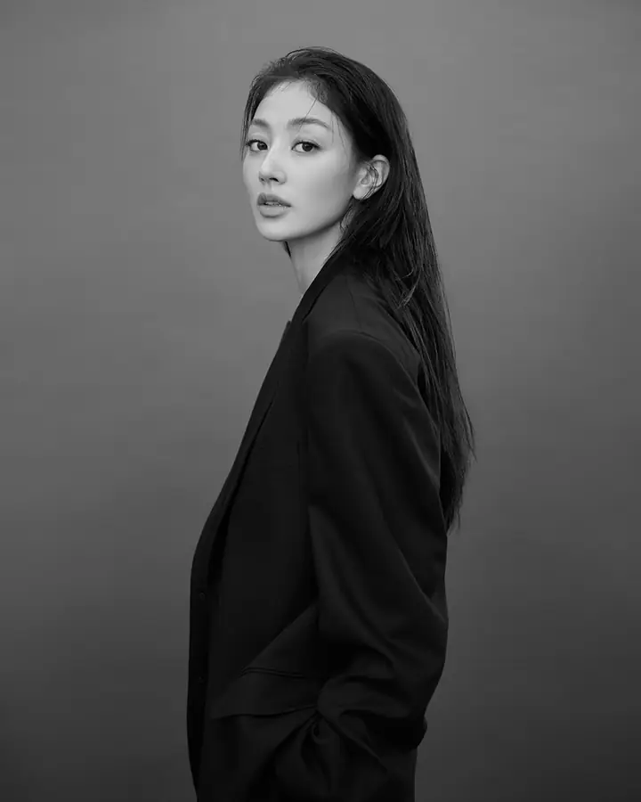 Jihyo in profile, looking back over her shoulder, black and white