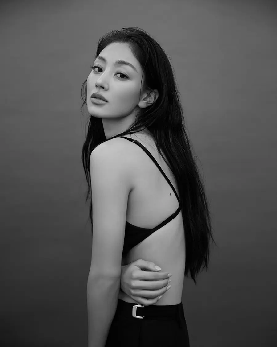 Jihyo looking back over a bare shoulder, black and white