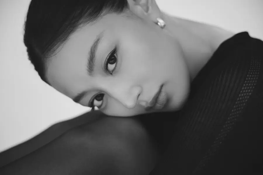 Black-and-white close-up of Jihyo resting her head on her knee