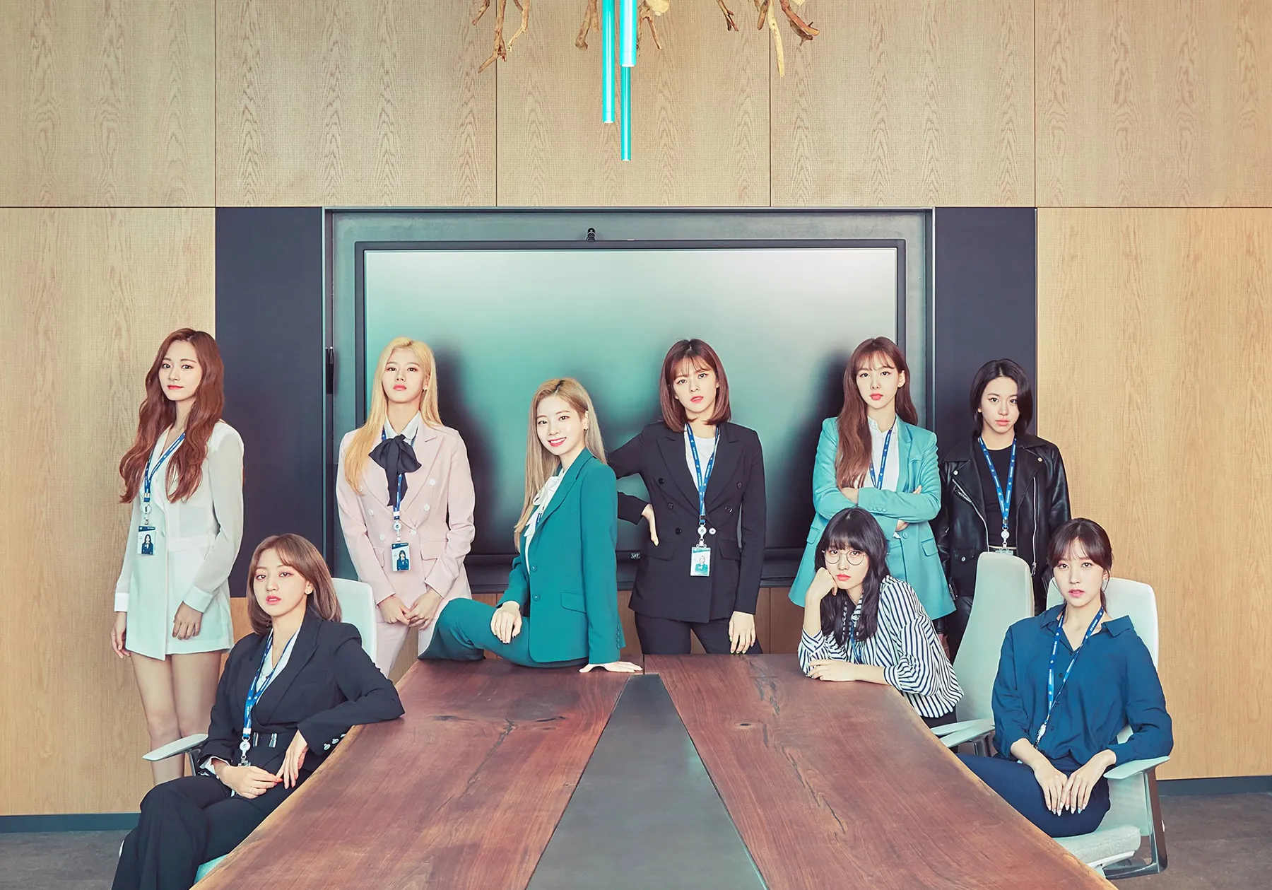 A team gathered around a long table in a meeting room, wearing staff lanyards